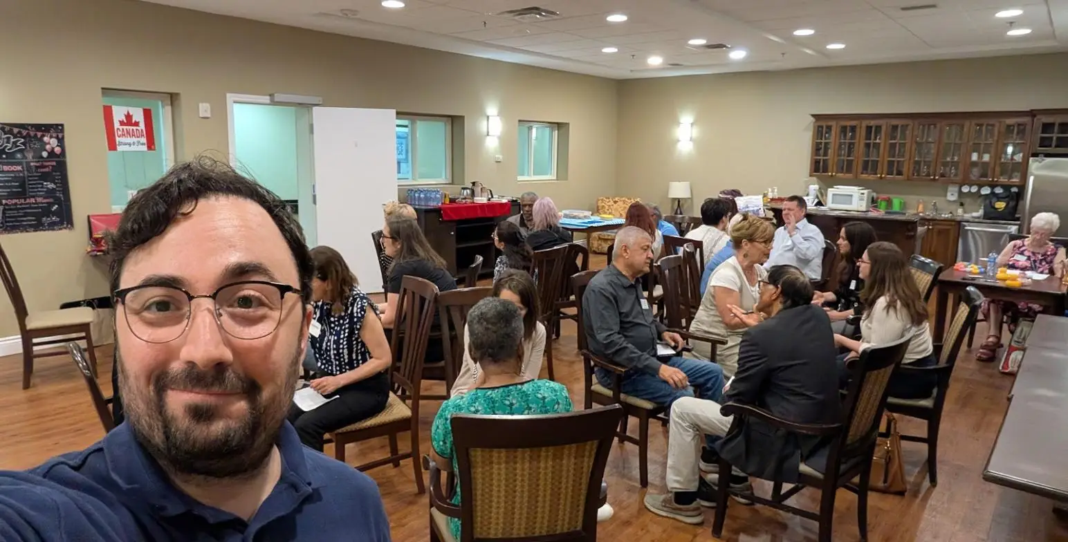 Community members in small-group dialogue at a Community Huddle session