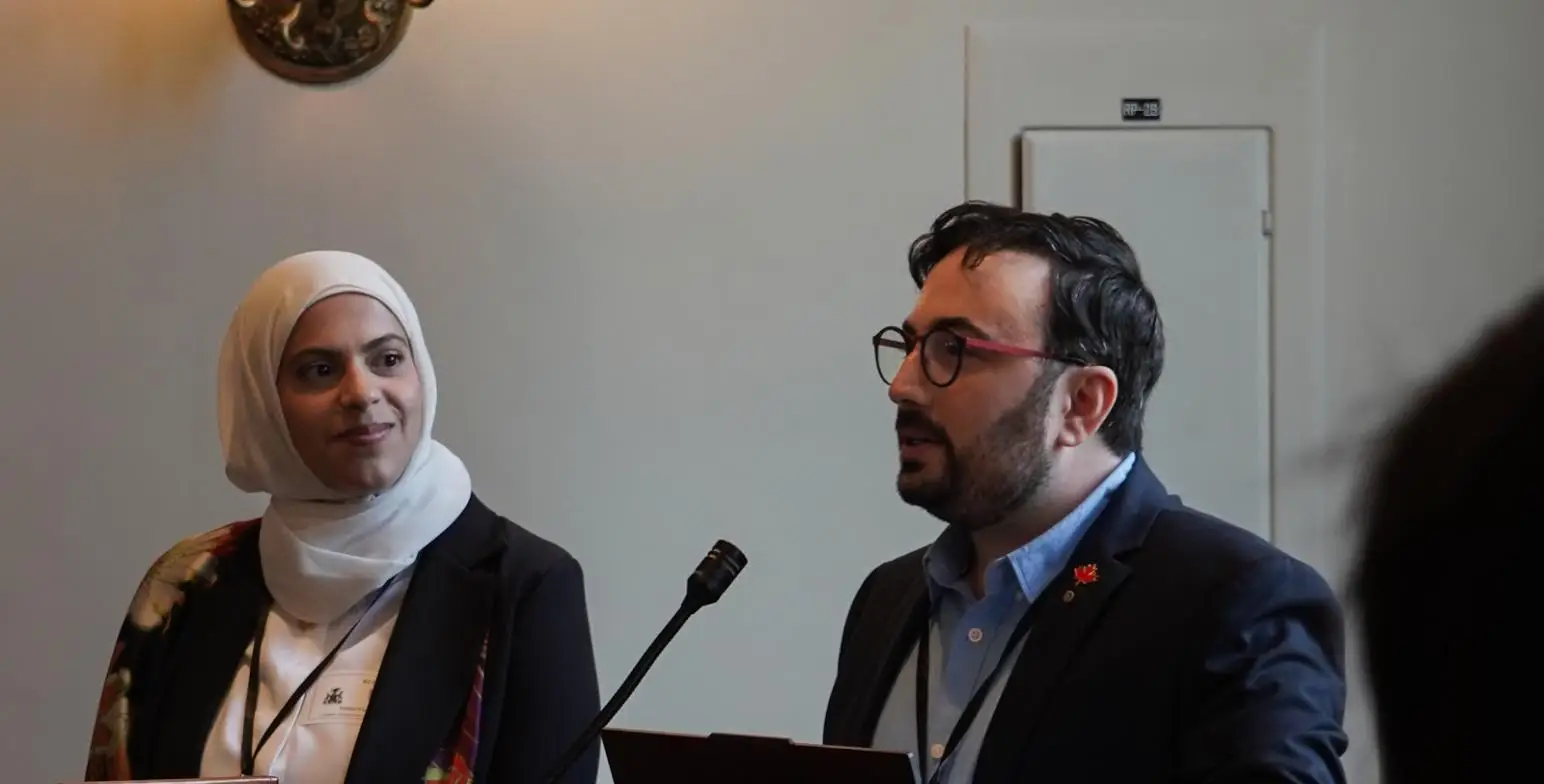 Hamza Arsbi speaking at a podium